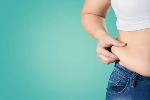 Image of woman pinching her love handles to show weight gain Bispham